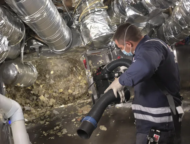 Norton Air Duct Cleaning specialist operating negative pressure cleaning equipment for thorough duct maintenance in Norton
